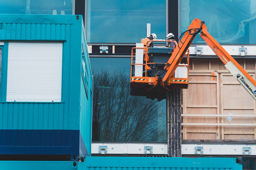 Workers on Elevated Work Platform a construction vehicle on a building