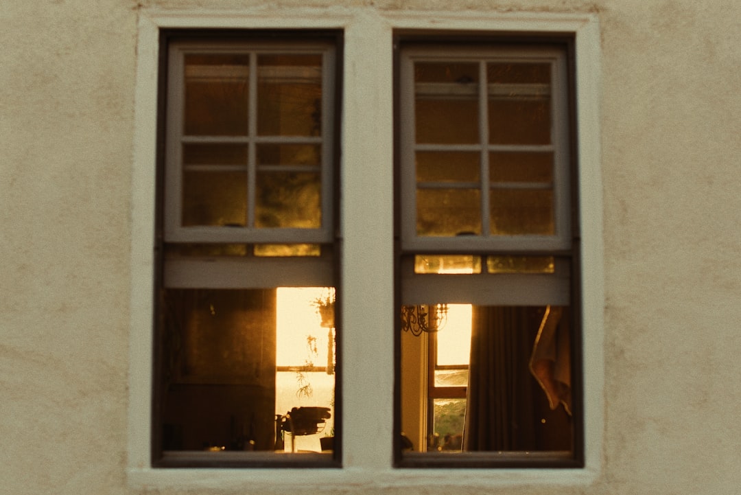 Two windows reflect a golden sunset and interior details