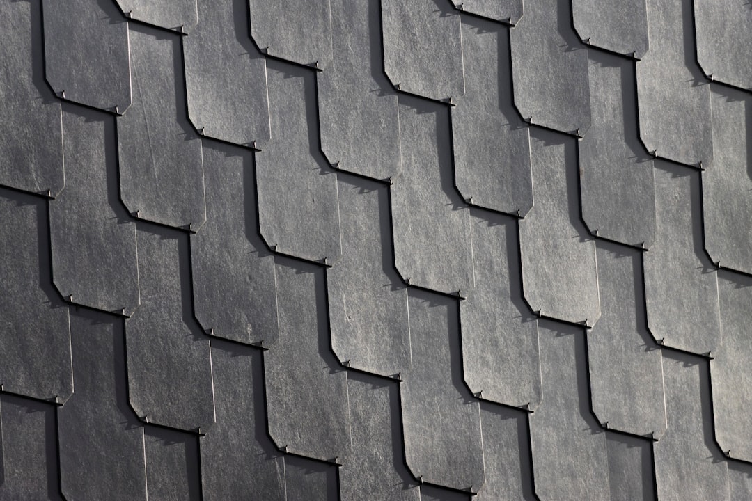 b84412b6a7404fabadc1d621af15412a Dark grey scalloped roof tiles create an overlapping pattern.