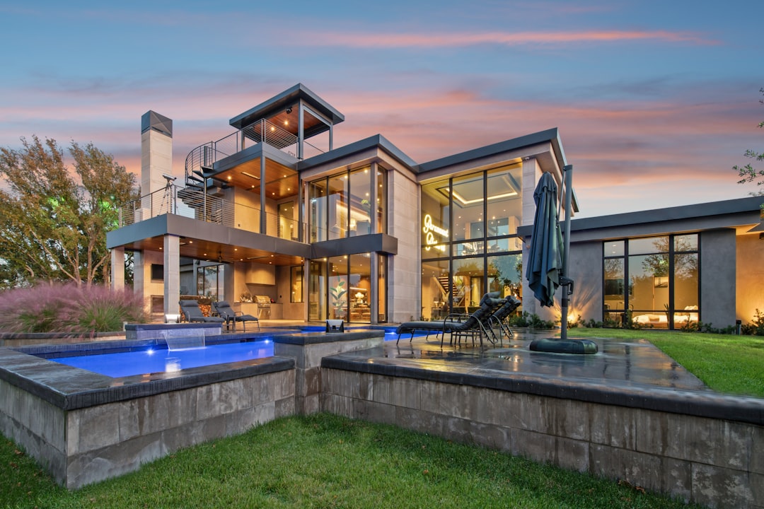 bad8734bd7f54cf4af57a7897004d9ce Modern luxury home with swimming pools at dusk