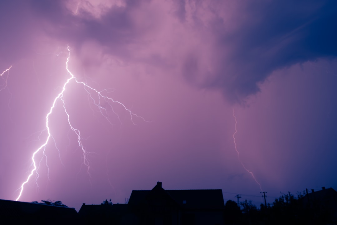 A lightning bolt is seen in the sky above a house