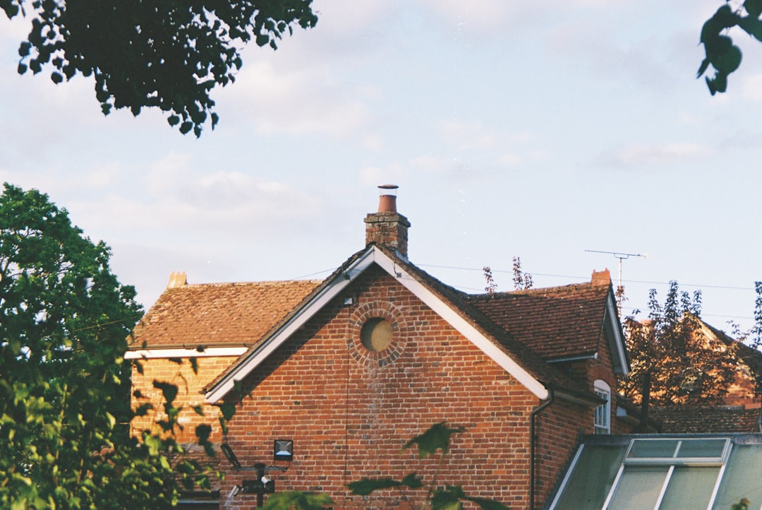 Traditional brick house with red tiled roof and green foliage