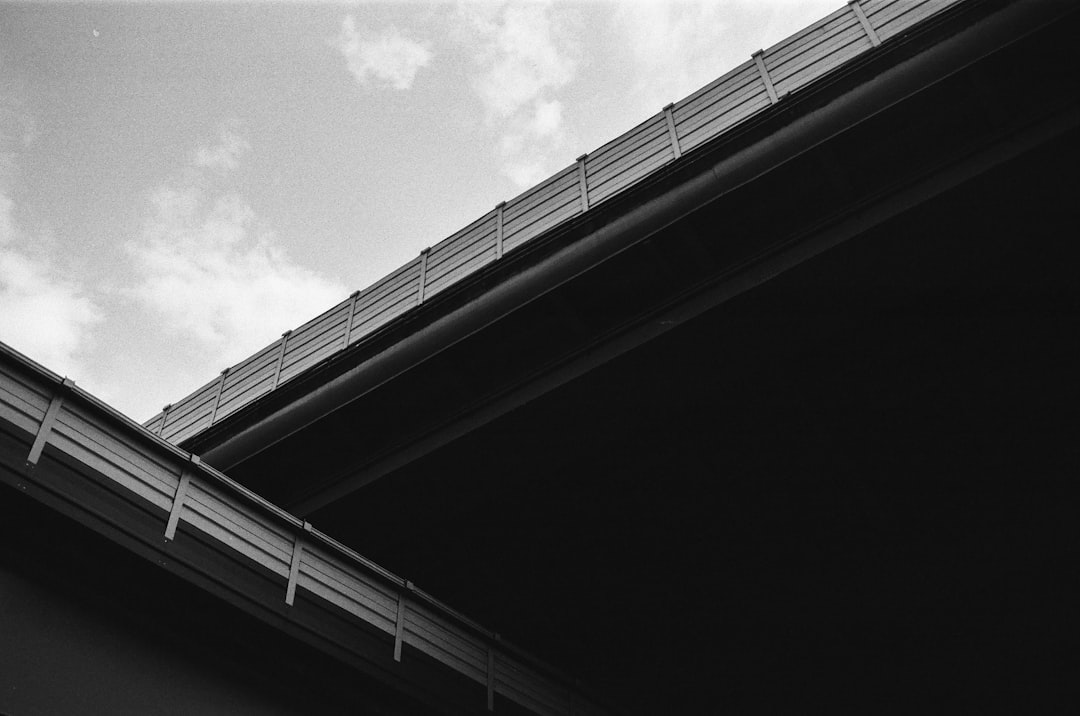 c1ab046314424f278a44a089c7c44410 a black and white photo of a building with a sky background