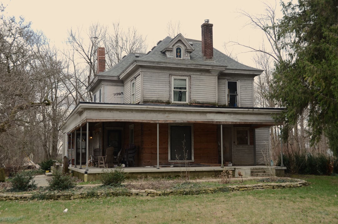 An old, weathered house with a large porch.