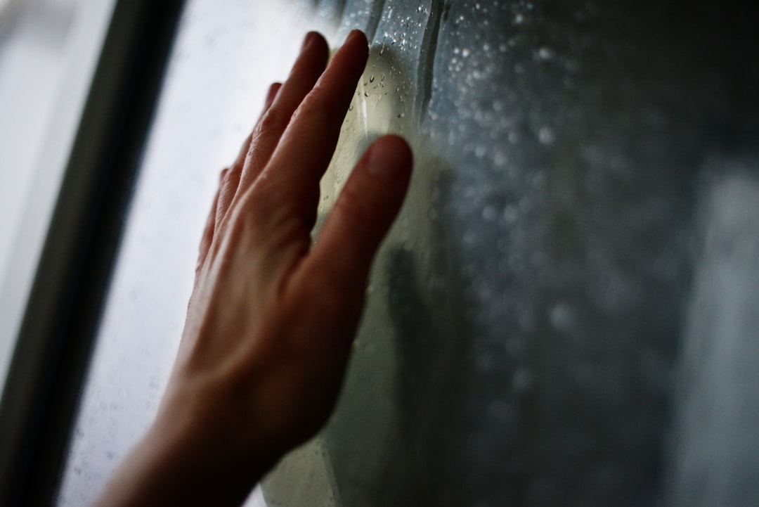Hand rests against a foggy window