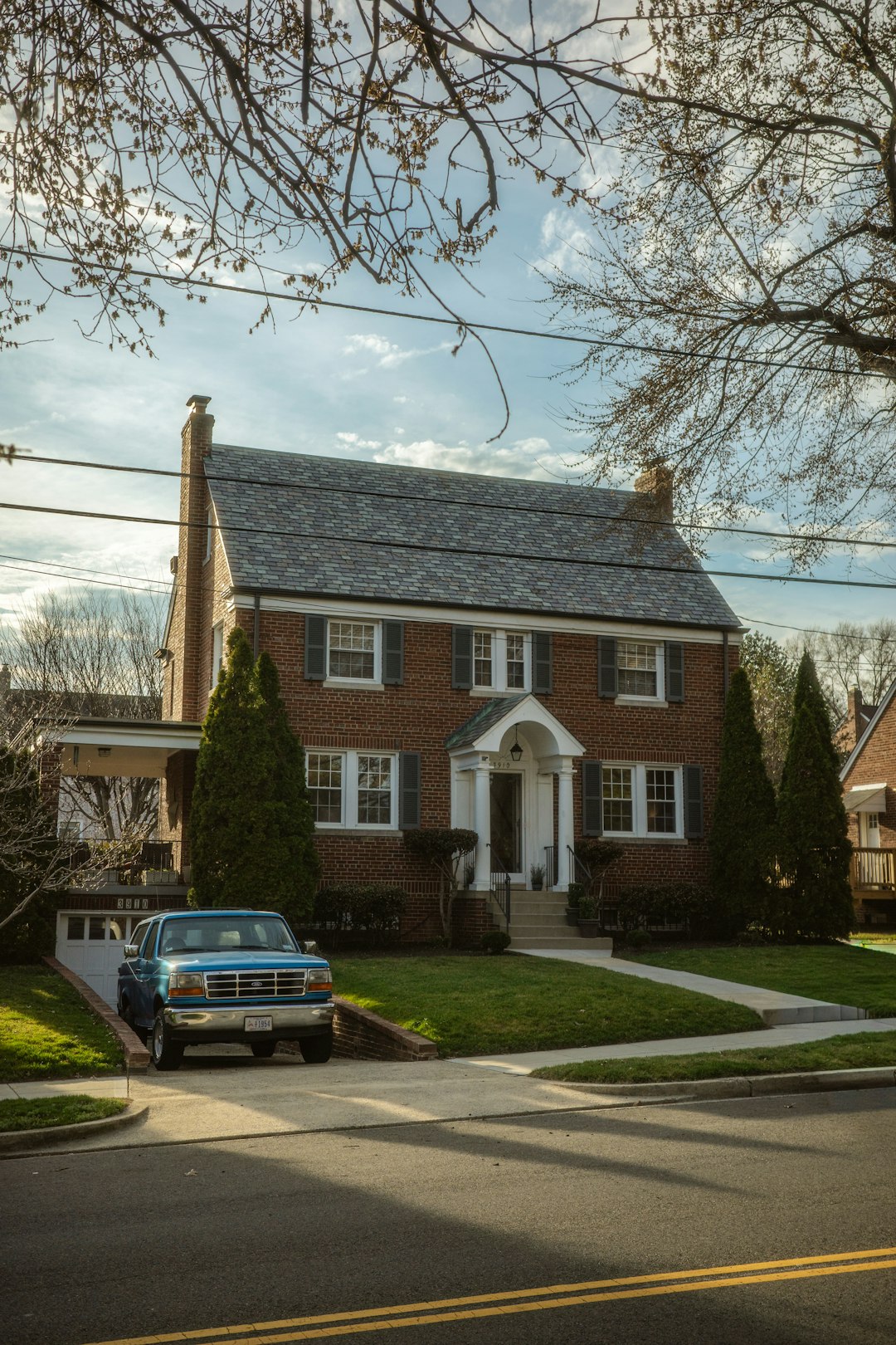 Brick house with a blue truck in the driveway.