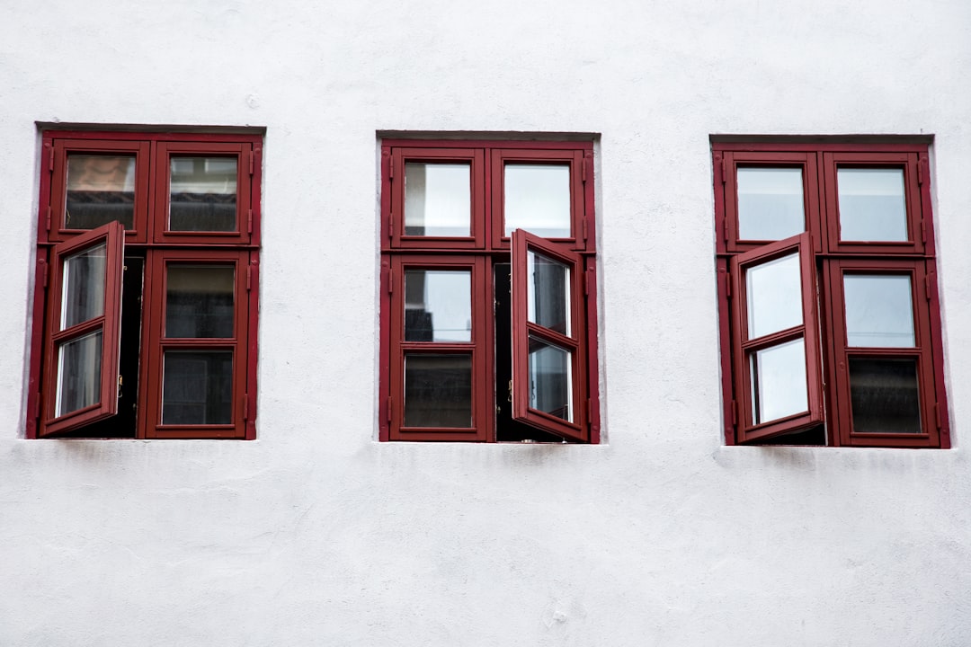 d462b6d0e63346c7890bf15f245f531f three open windows on the side of a white building