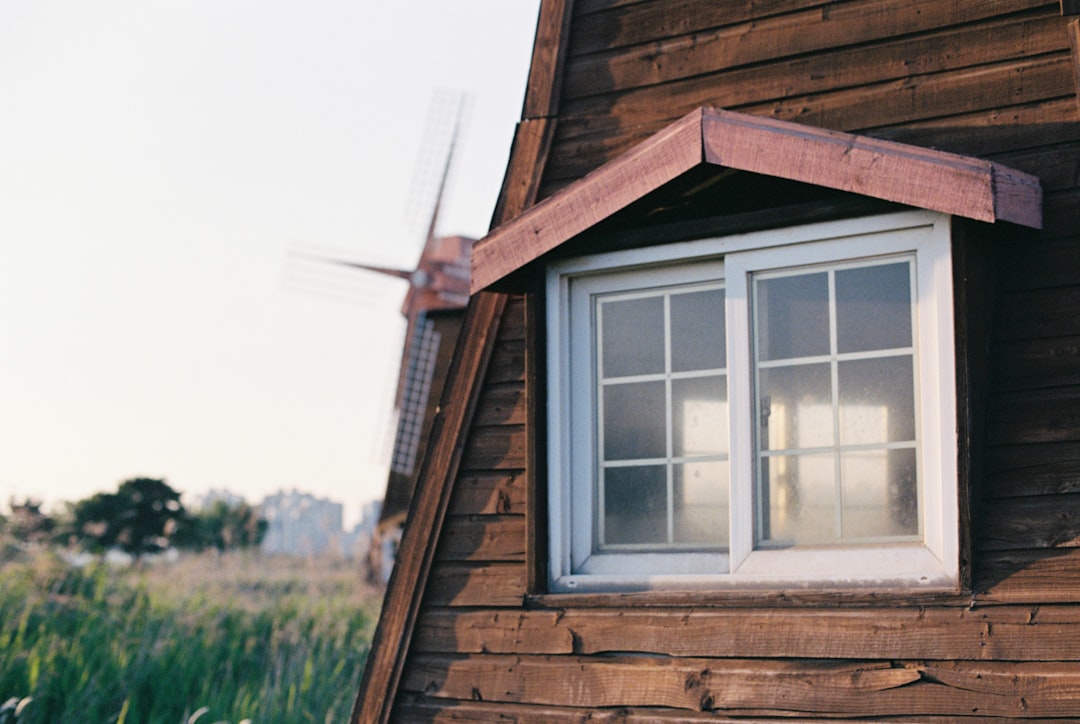 Wooden windmill exterior with a window and field