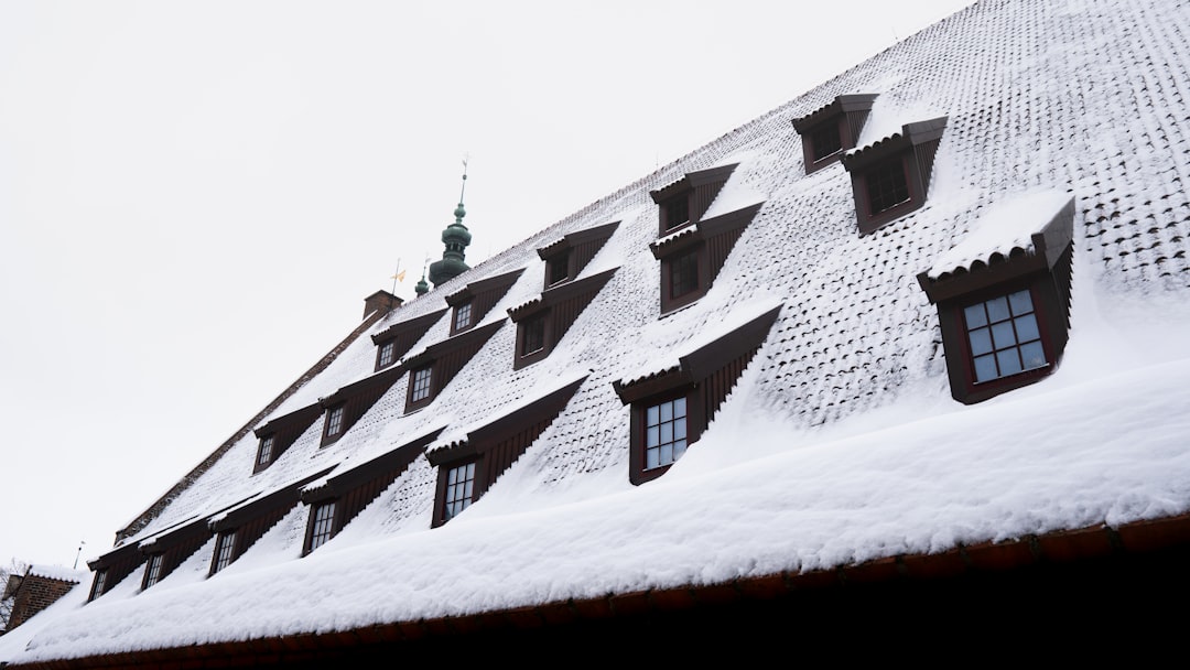 e7c78096dccc4a0084af630f89357f8c Snow covered mansard roof with many dormer windows