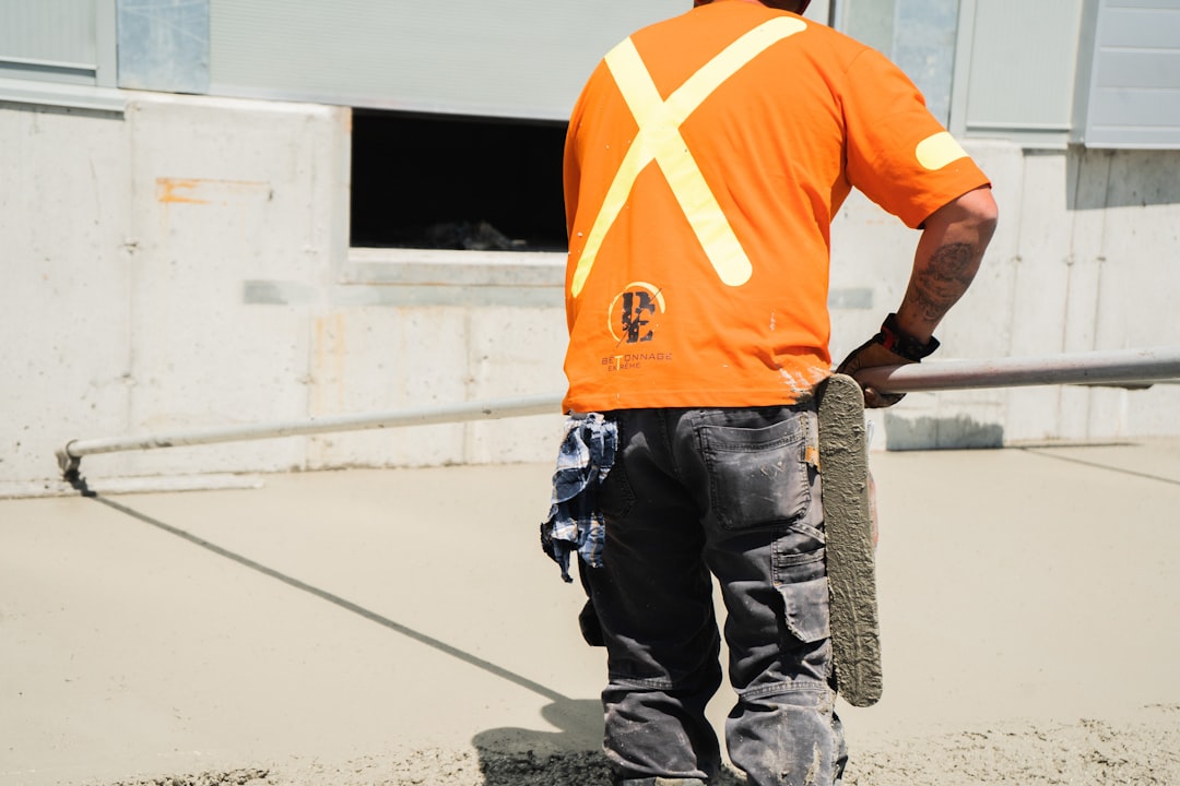 a man in an orange shirt is holding a skateboard