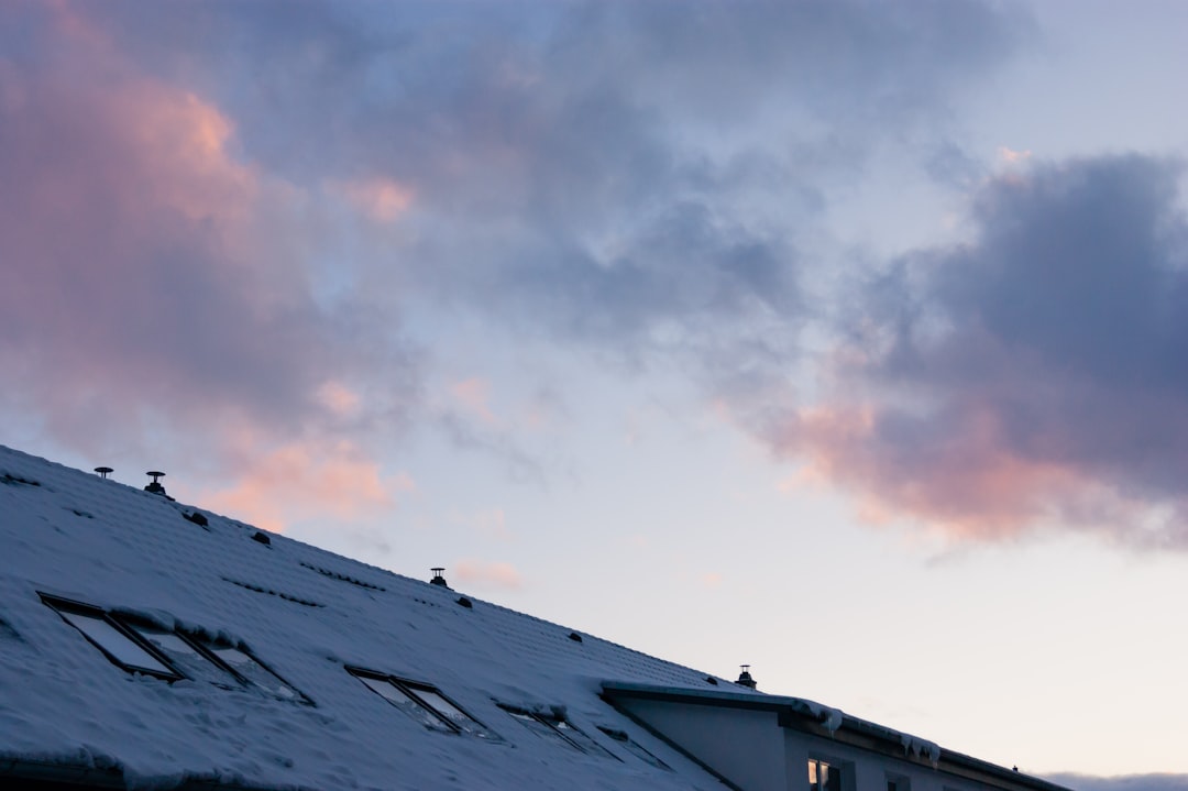 Snow covered roof with pink clouds in the sky