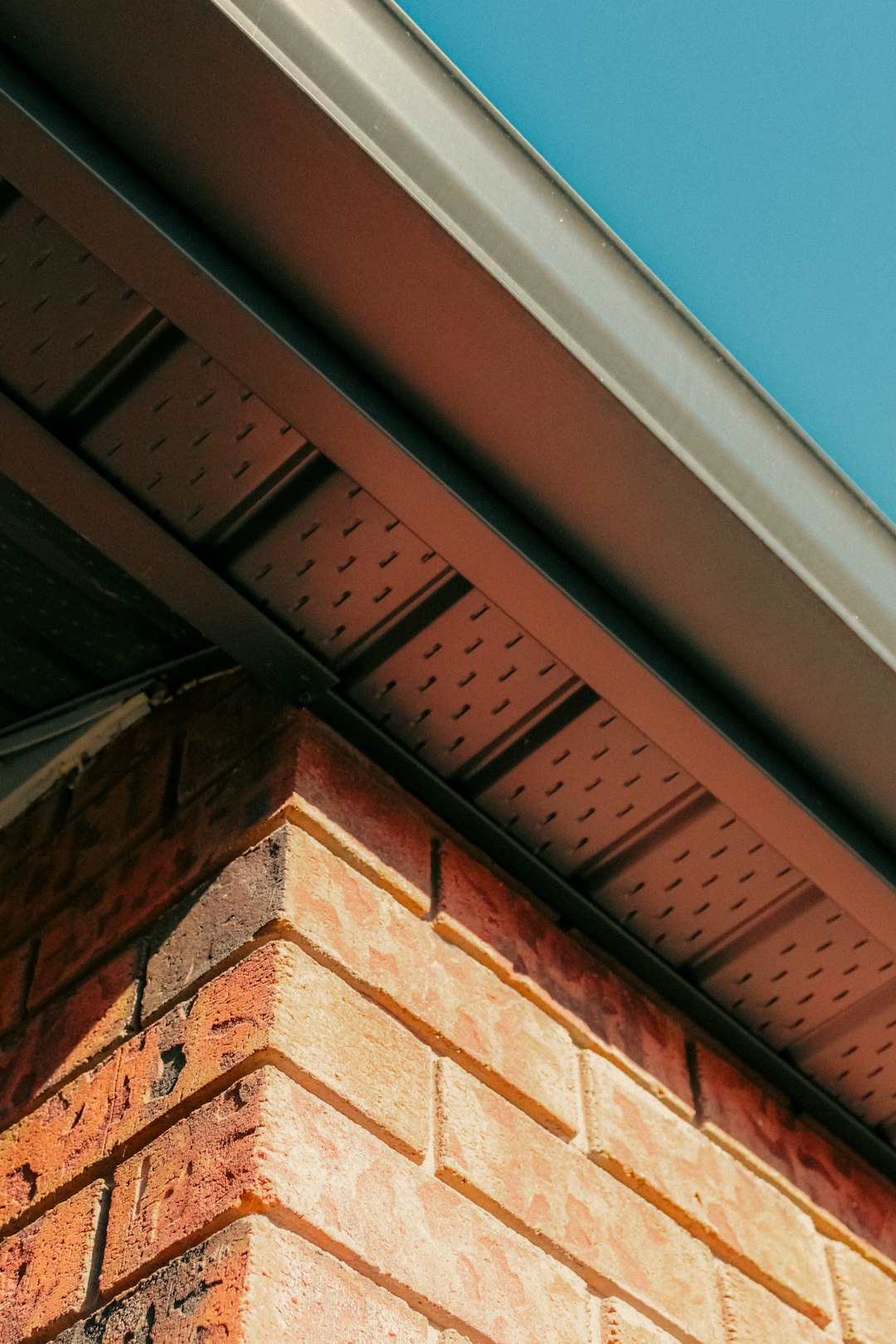 ed030c55127540a39bd2be8c2f78c8d0 a close up of a brick building with a blue sky in the background