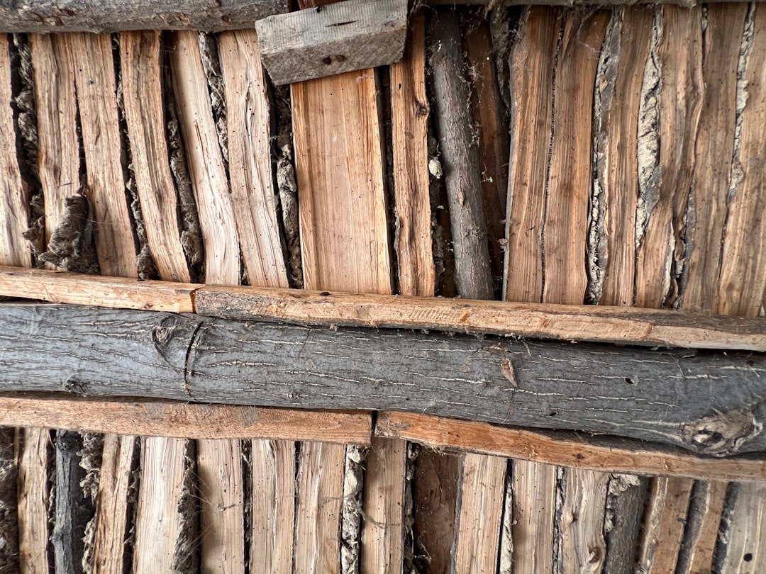 Rough wooden planks and logs form a rustic wall
