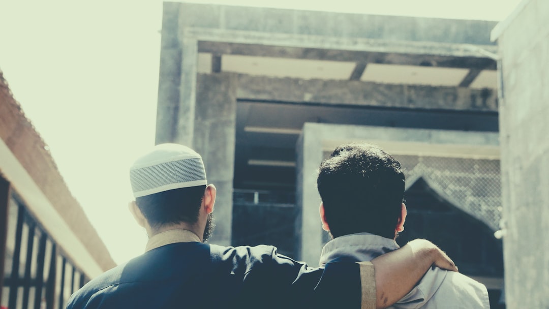 f87062826a60452cada875e585a97c07 a couple of men looking at a building