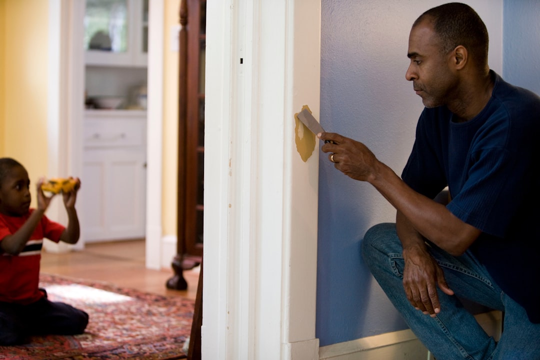 082b52dcd07e447db8bf9e06e2c915c4 man in black crew neck t-shirt and blue denim jeans sitting on white wooden door