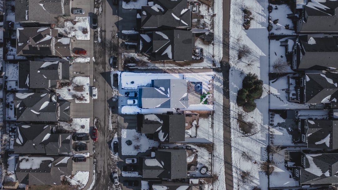 083e39fcc774470bae182c1ea314ecd6 Snow-covered residential neighborhood with houses and streets from above