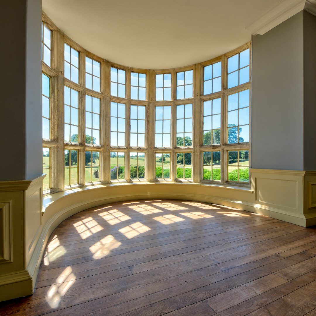 0dcda03cf4324afbadd18e318f0186a4 Large curved bay window with sunlight on a wooden floor