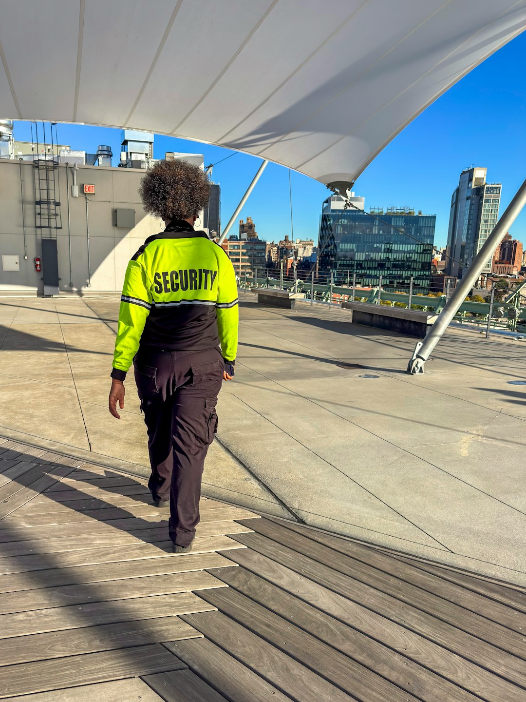 Security guard walking on a rooftop overlooking city