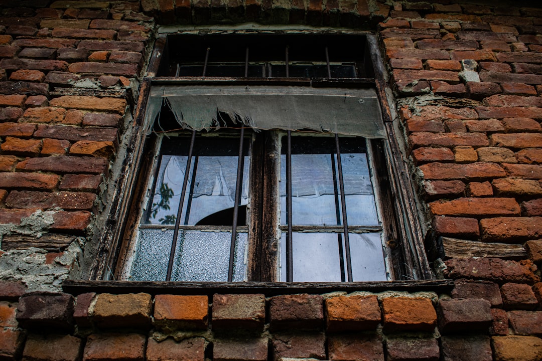 an old brick building with a broken window