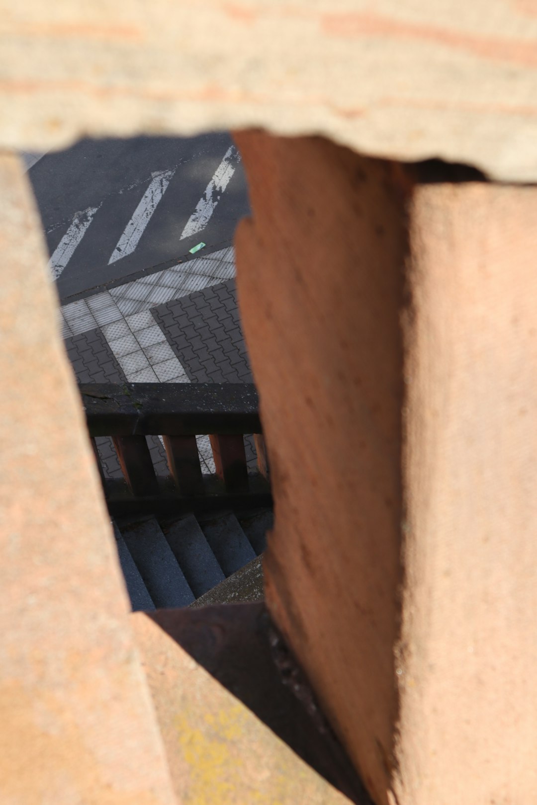 a view of a street through a hole in a wall