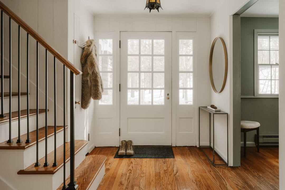 2274140e19f44123ac97071c0204c570 A cozy entryway with wooden stairs and a glass door