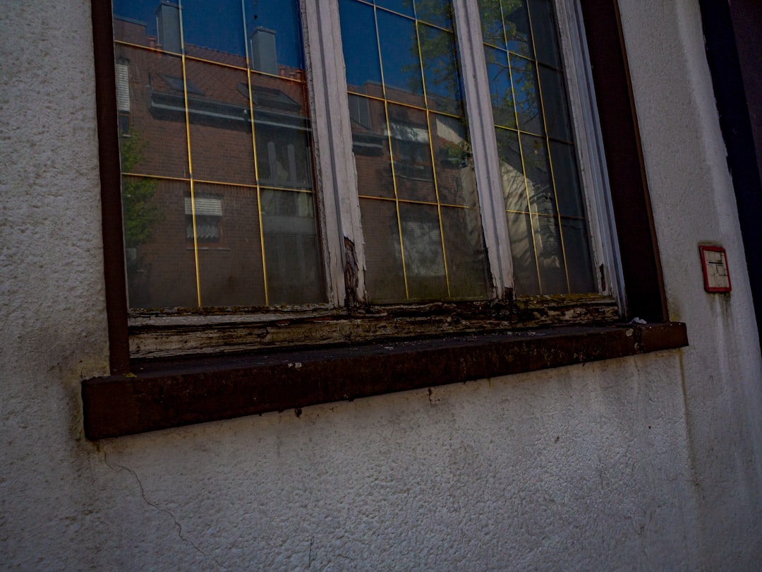 2d192a8073fd4b98883a6035b0adade7 Old window with reflections of buildings