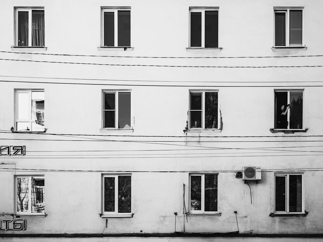 White building facade with multiple windows and wires