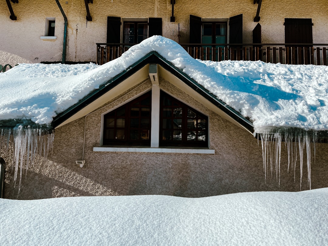 3ff2fd6c11d14d488908b70fb6c2a5b6 a house covered in snow with icicles hanging from the roof