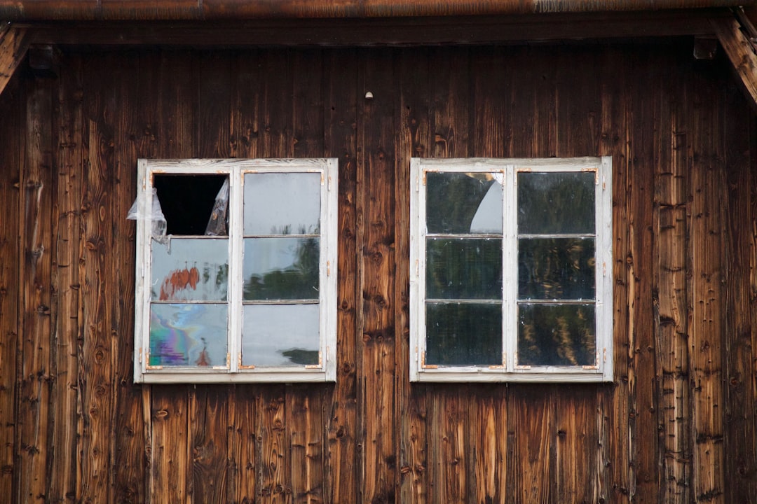 4756220a7c79430fa1f23c51e5cfe60a two white framed glass windows on brown wall