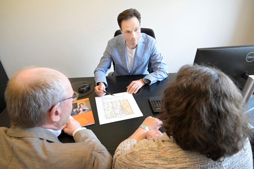 50fe095d84384534b7fce5e638a5c0ae Consultant explains plans to a couple during a business meeting