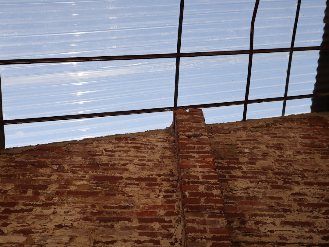 a brick wall with a window and bars on it