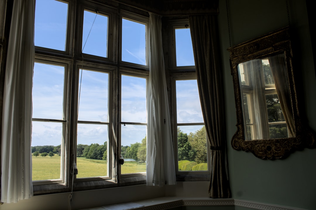 A window offers a view of green fields
