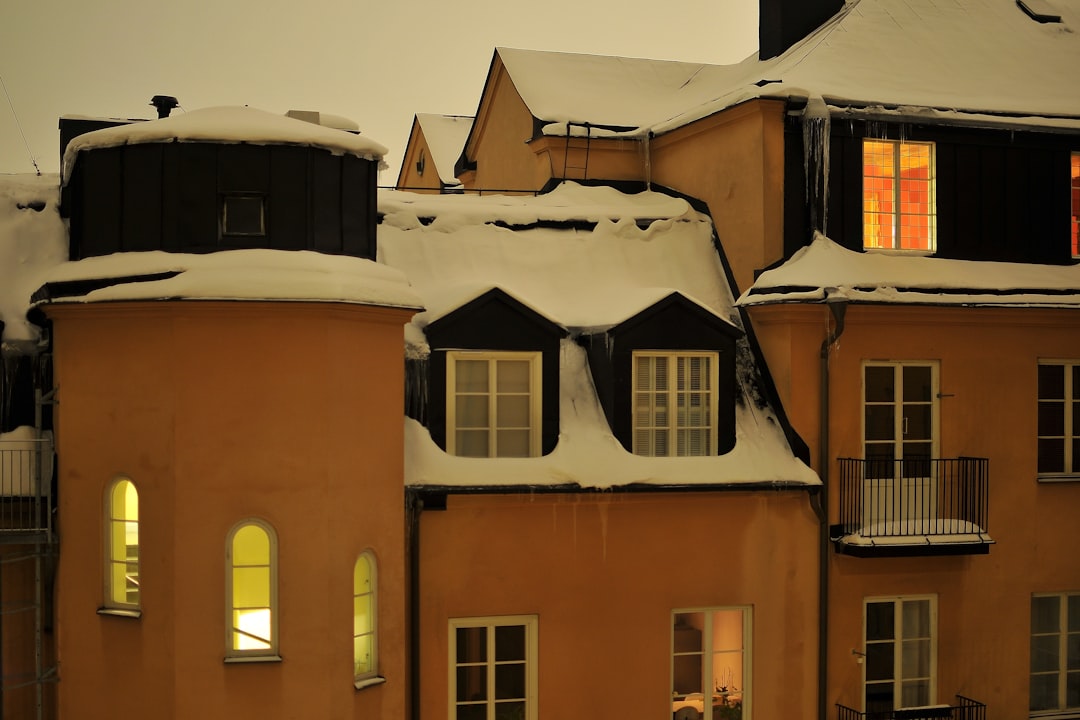 629b356ef0424605b68bc4dc73328324 Snow-covered buildings with illuminated windows at dusk