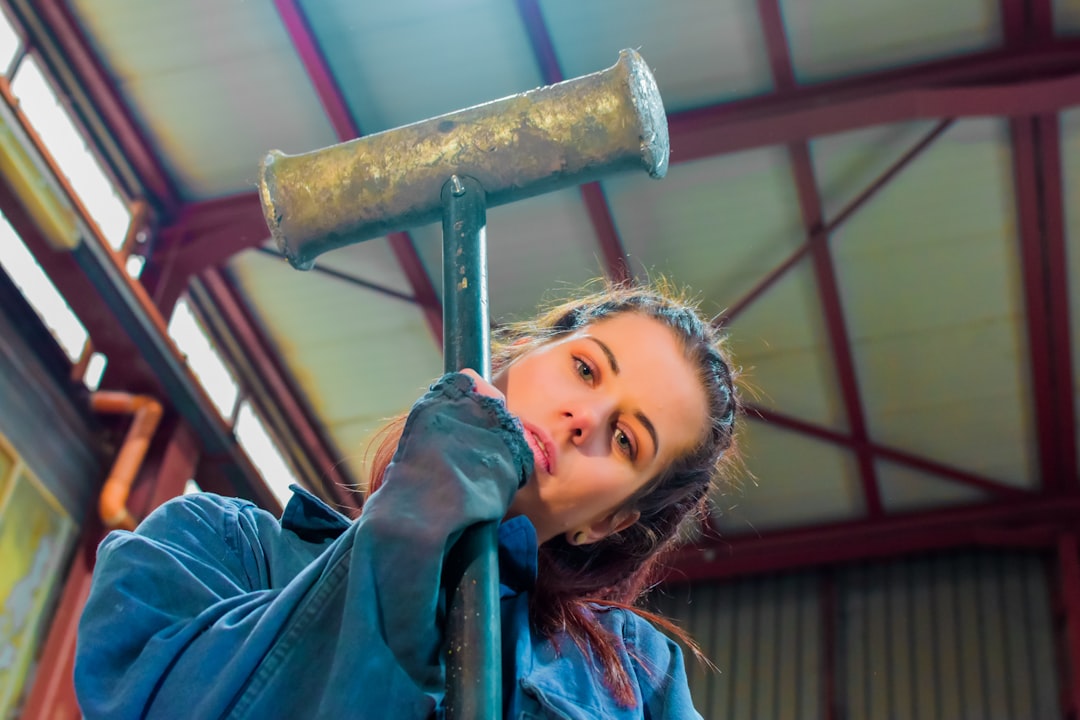 a woman holding a large hammer up to her face