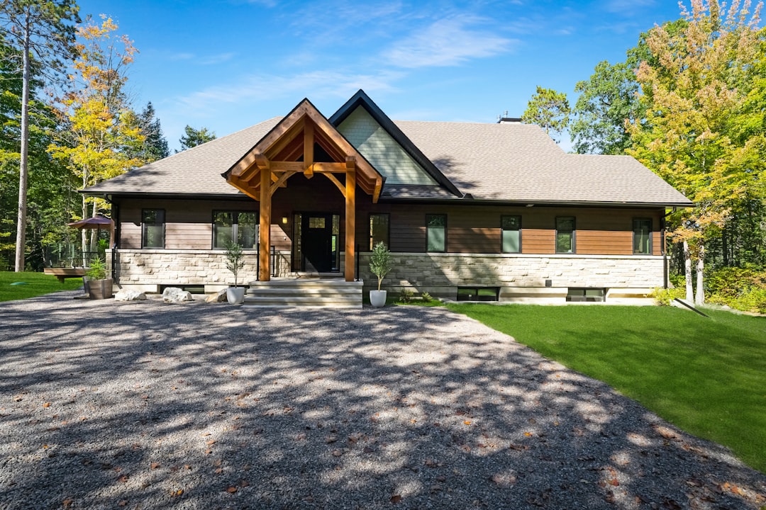 70819fc3e4174392ba4ec0463322bfbb A modern house with stone and wood siding under a clear blue sky