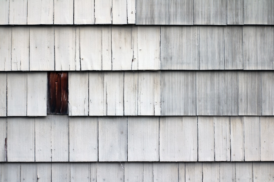 7442fde4bf10437b82387f5f38e3b0b0 Close-up of weathered wooden shingles with a missing one