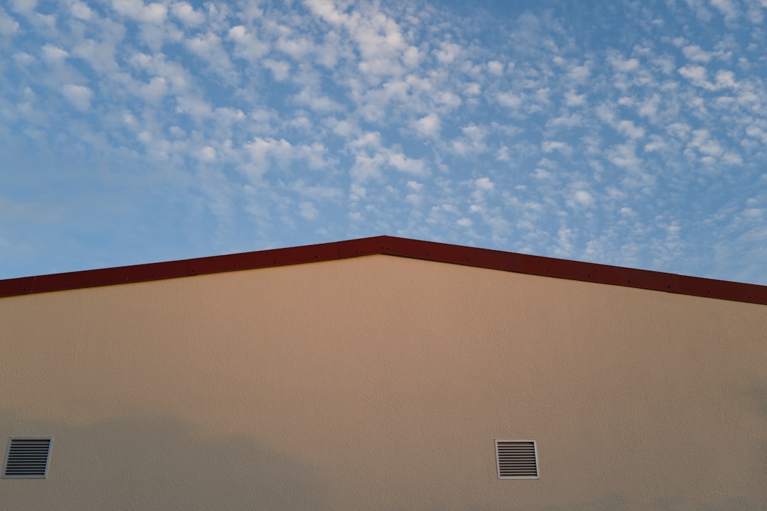 7c902d396b824f7781cc99e6d0a538c1 Building roof and blue sky with scattered clouds