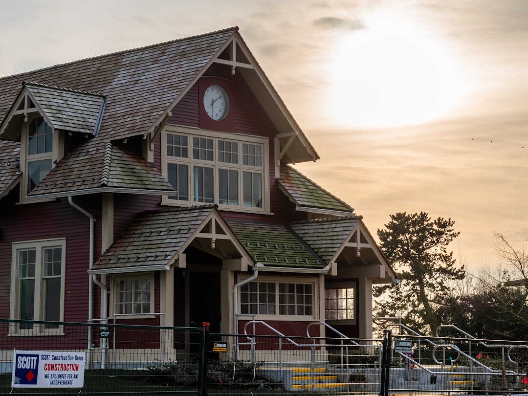 7cdf4649349e44c6ba55f5e3ed03b1b2 a red house with a clock on the front of it