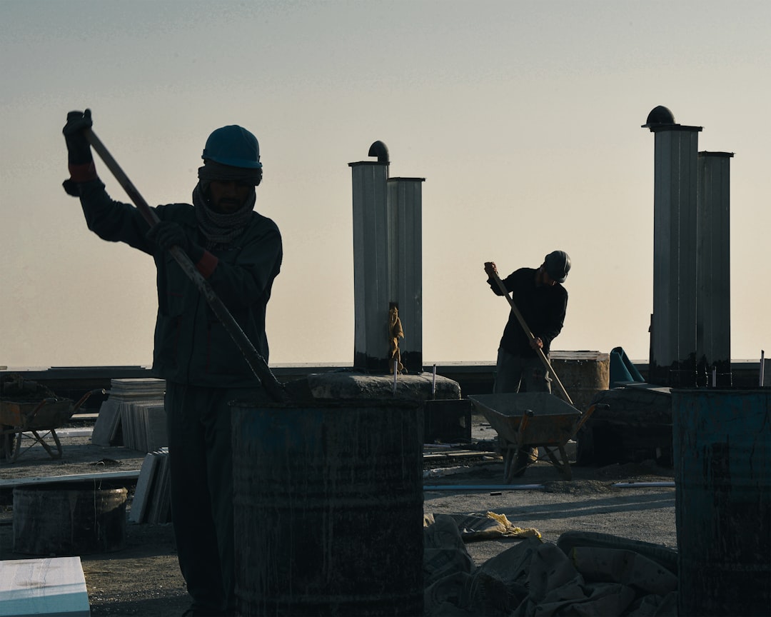 7fe55df7b6e54020b05b30517049d171 Construction workers silhouetted against the sky