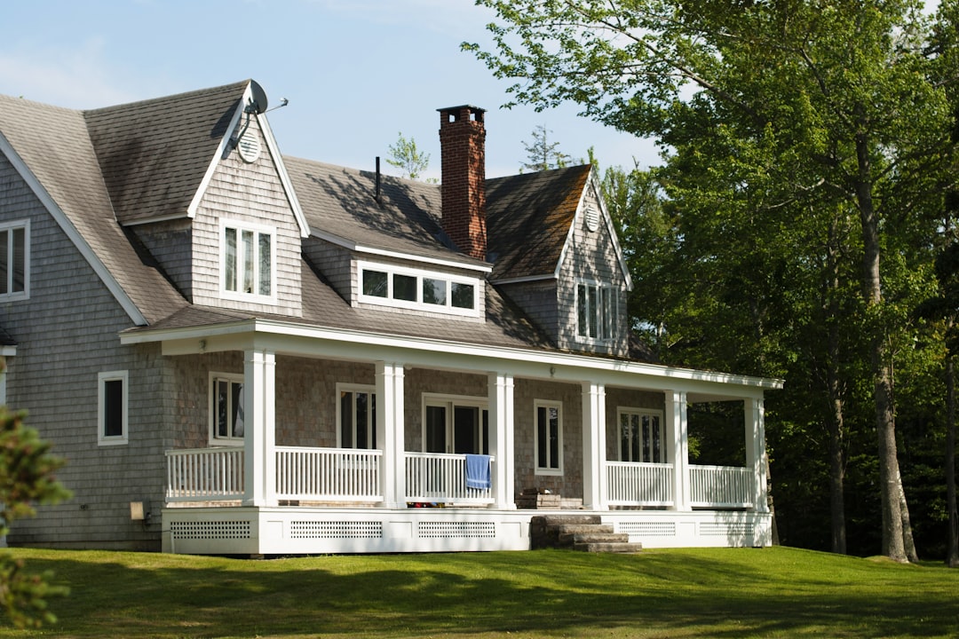 802f3928cc8541e7a4be5840d6000932 white and brown wooden house near green trees during daytime