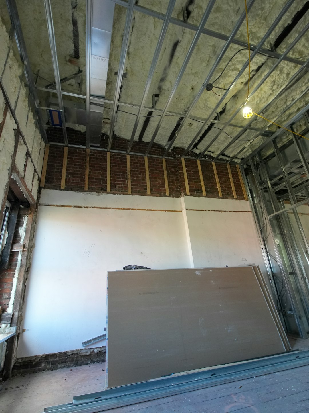 Interior construction with exposed brick and drywall sheets