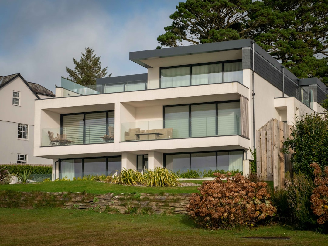 8e6fbd4d3fd9422389ccd5ad4a47b842 a large white house sitting on top of a lush green field