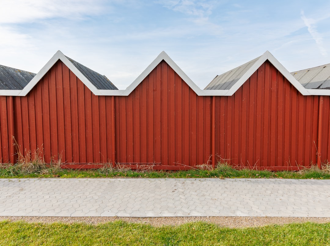 9526218a5829434789751654cf7939dd Red wooden wall with zigzag roofline under sky