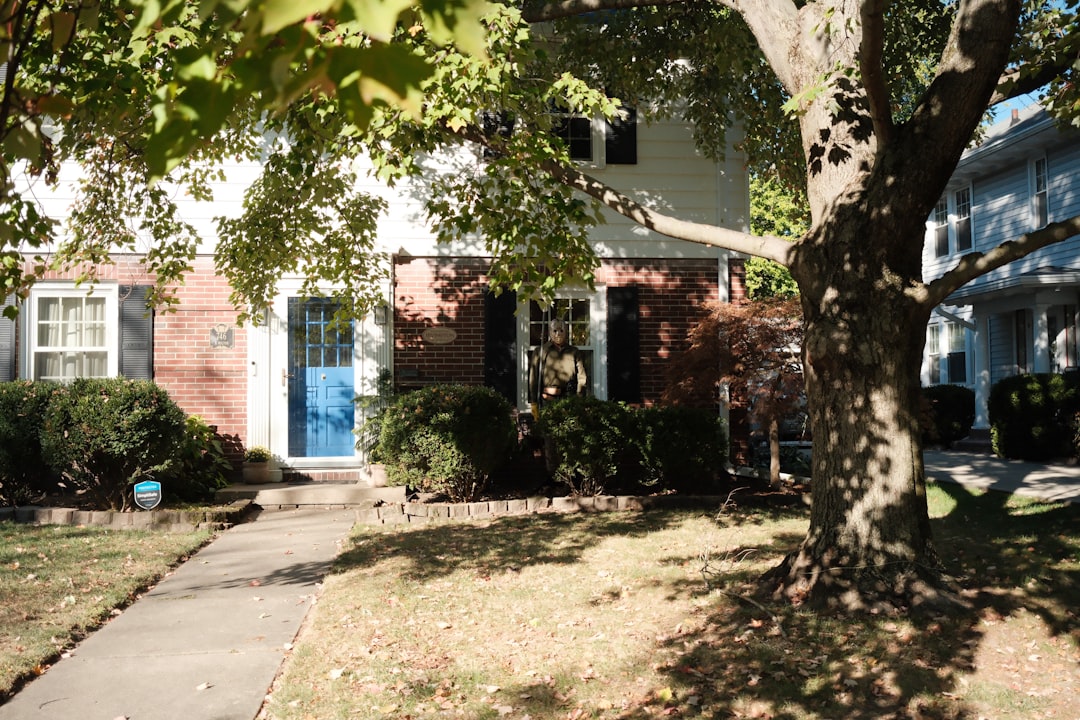 a0c119c9ca314708a27d1e8a88a692a6 A suburban house with a blue door and trees