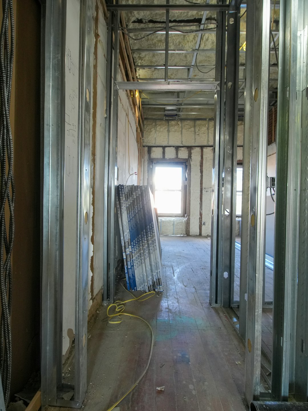 a4cbf144985045fb80cc3cb01a762678 Interior hallway under construction with metal studs and drywall