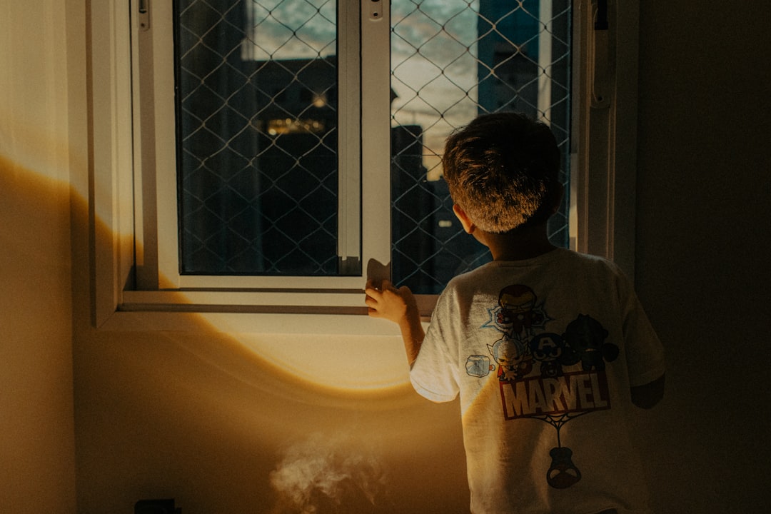 Boy looking out a window at night