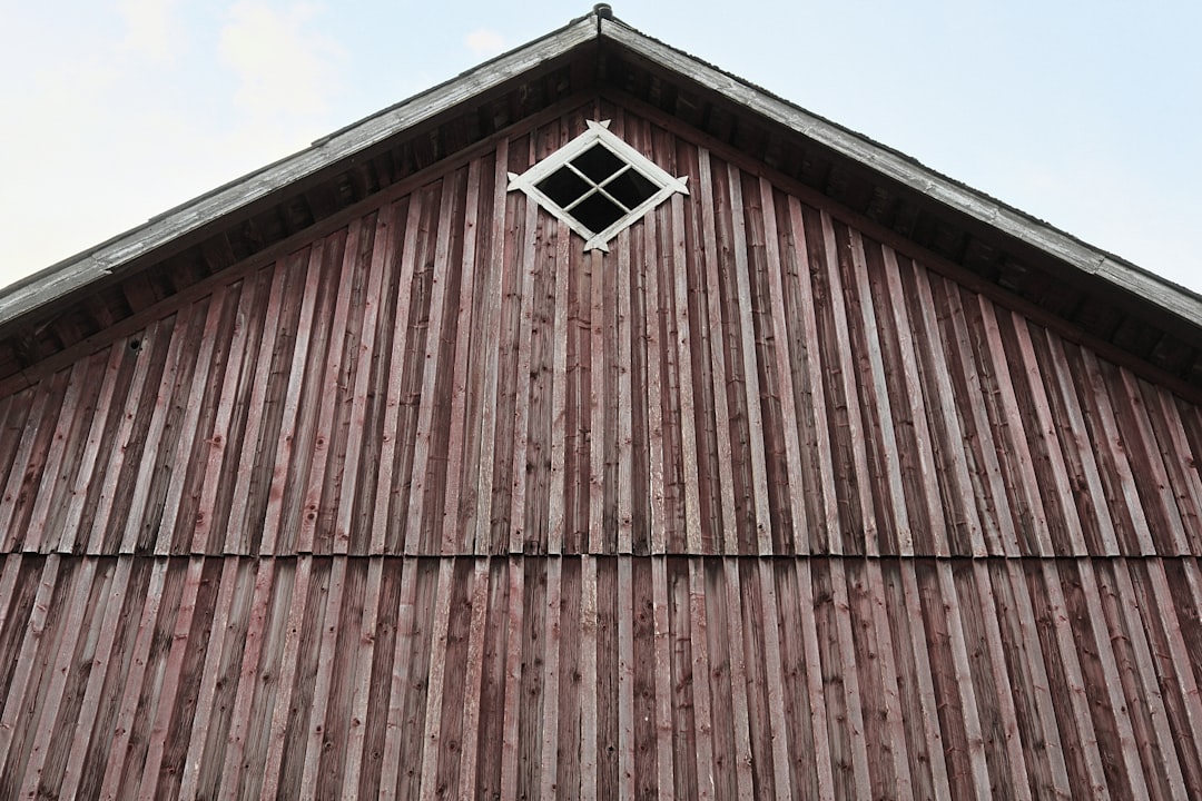 Red wooden barn gable with a small diamond window