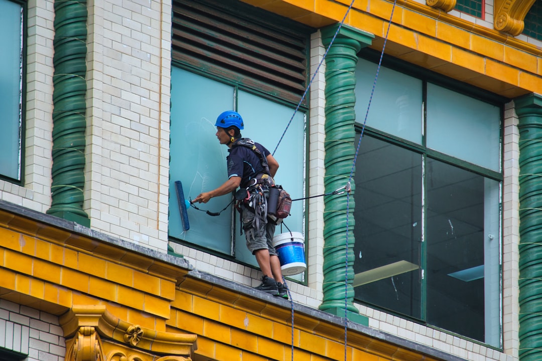 A window cleaner works high on a building exterior