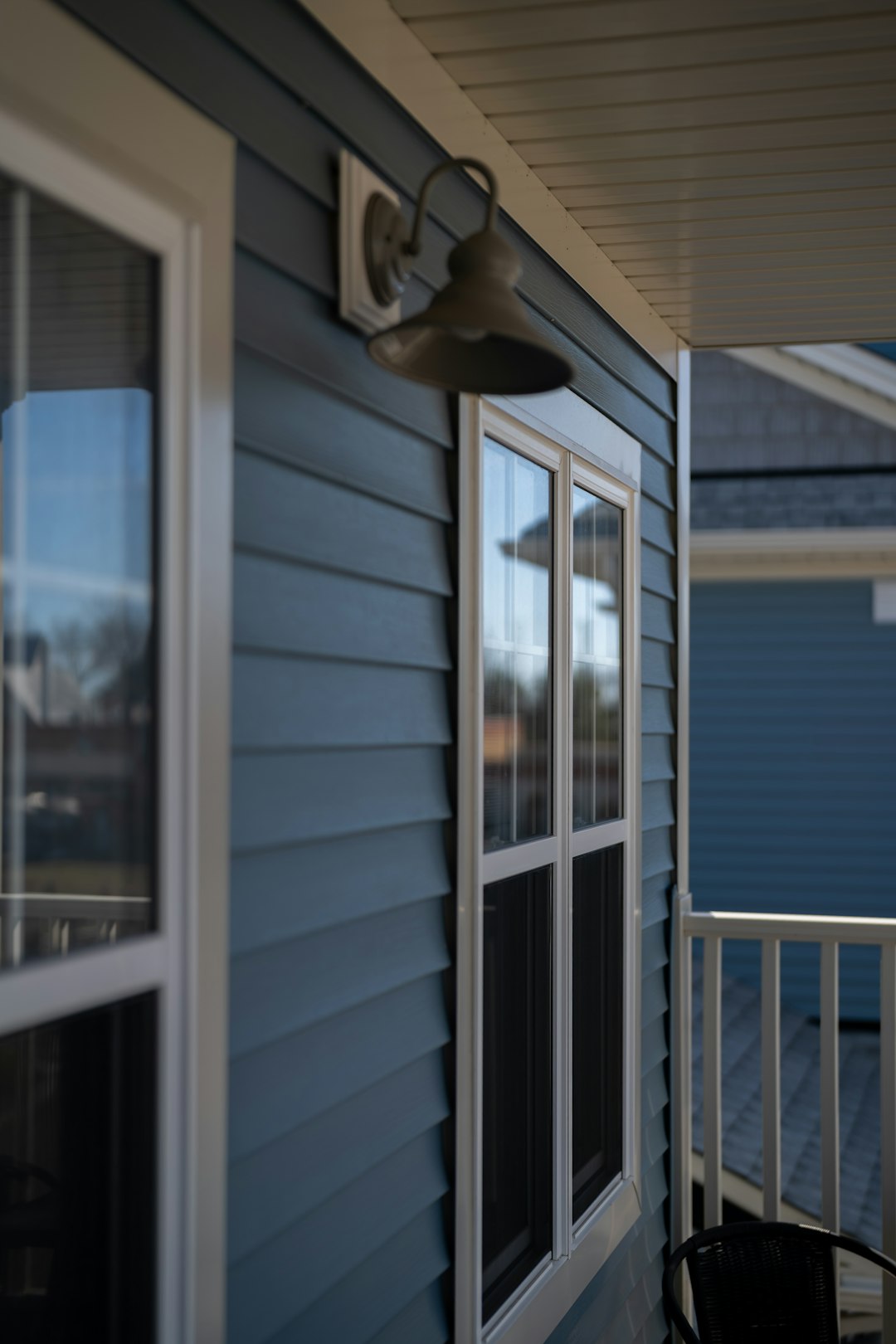 Blue siding house with white trim and outdoor light