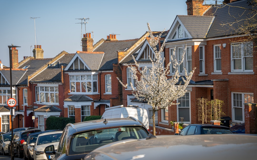 f8911b7df875411b95534af3cb02c3df Row of brick houses with parked cars on street